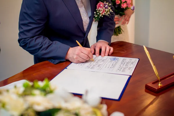 Groom signing marriage license