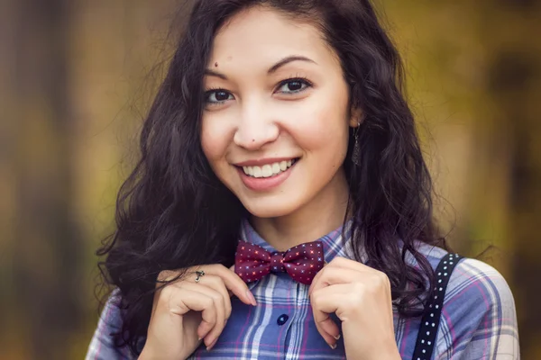 Smiling girl straightens bow tie