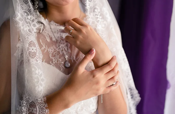 The gentle hands of the bride in lace white dress