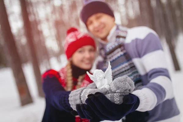 Couple in love holding in the hands white angel toy