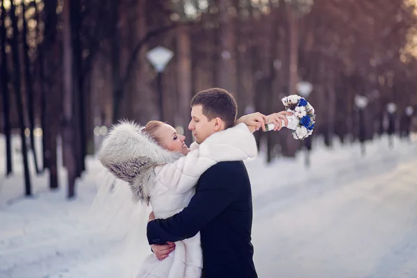 Couple in love bride and groom embrace in a wedding day in winter