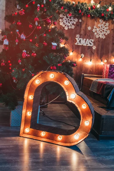 Studio interior with Christmas tree and illuminated heart