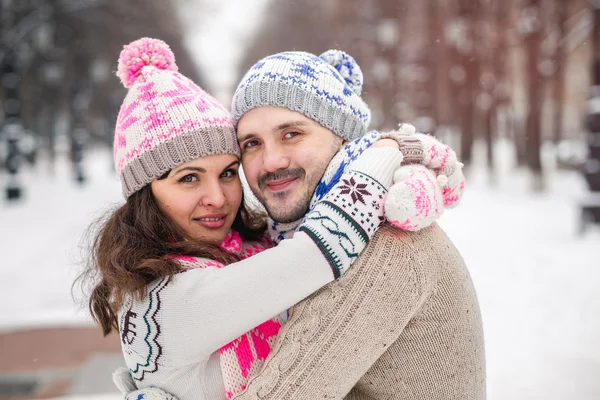 Portrait of young smiling couple in scarf and sweaters in winter