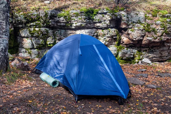Tent in forest near big rocks