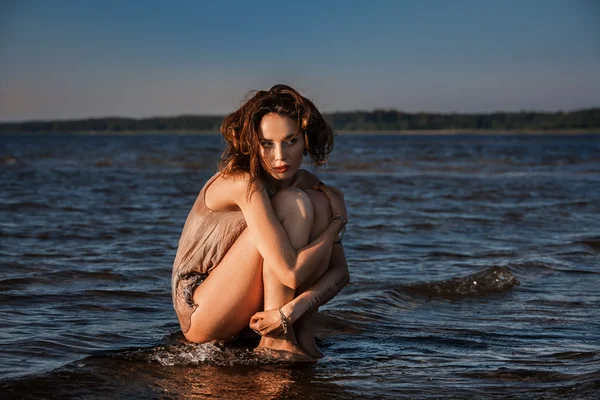 Seminude woman against sea background