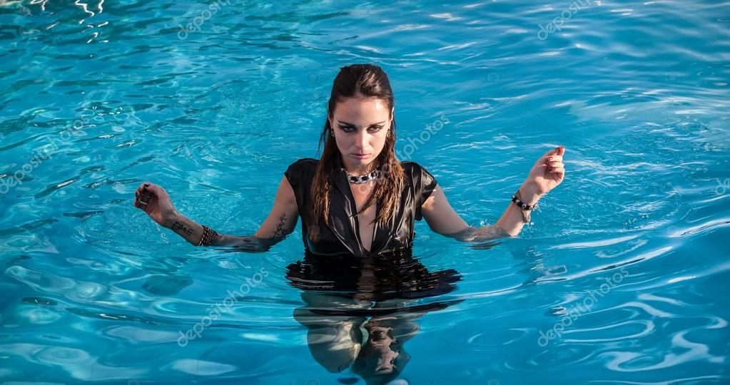 Wet woman in black dress in a swimming pool — Stock Photo © palinchak