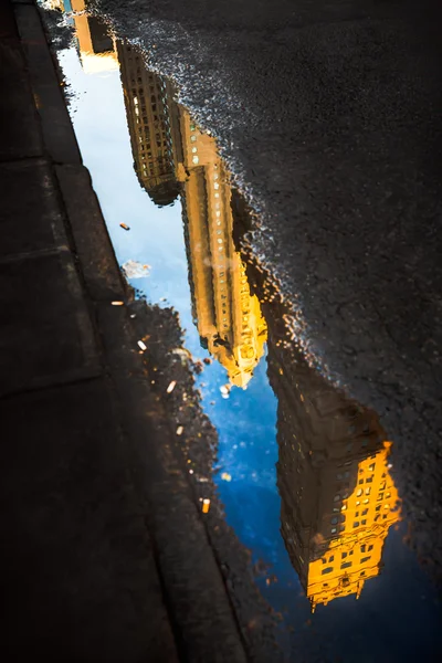 Streets of Manhattan. Skyscrapers reflection in puddles