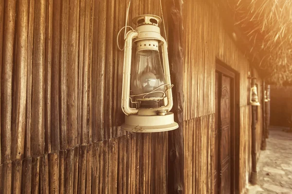Old fashioned vintage kerosene oil lantern lamp with aged wooden wall