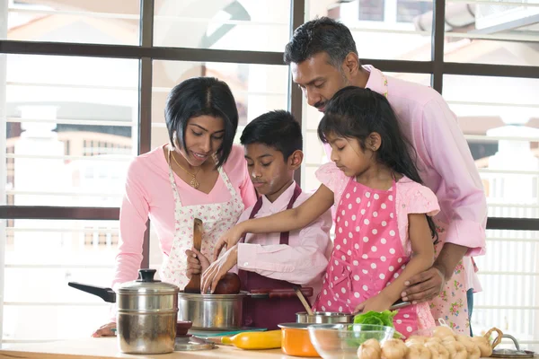 Indian family spending quality time busy cooking at home