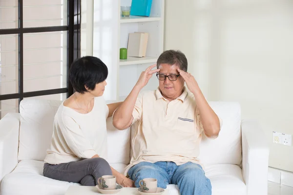 Asian senior couple having headache