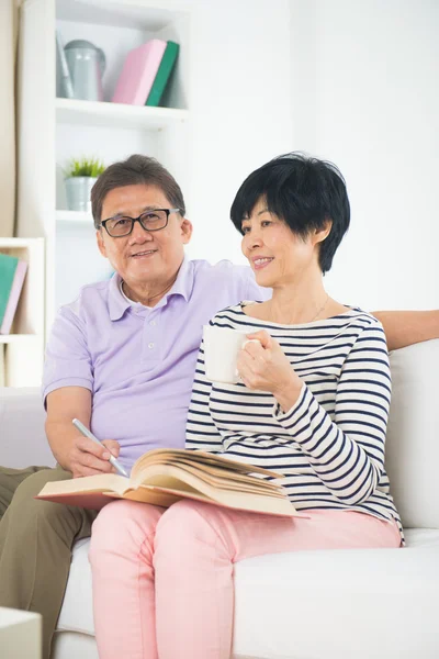 Senior asian couple reading a book