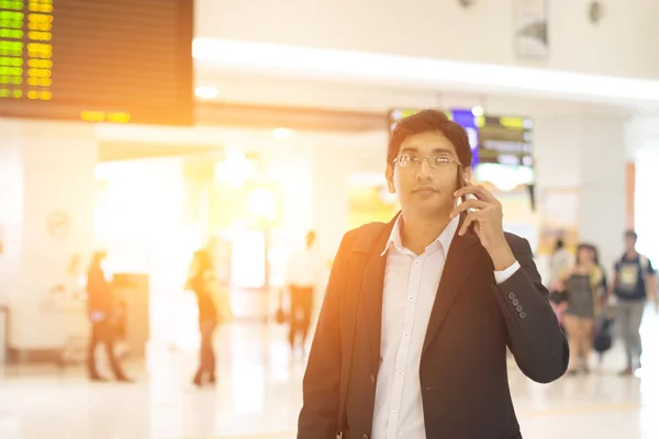 Indian male with phone at airport terminal