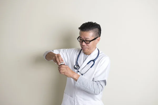 Asian senior doctor with pills