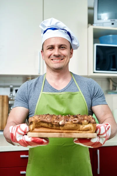 Cook holding cake with walnuts
