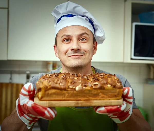 Cook holding cake with walnuts