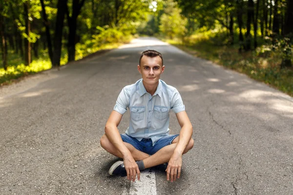 Boy  sitting in the middle of  road