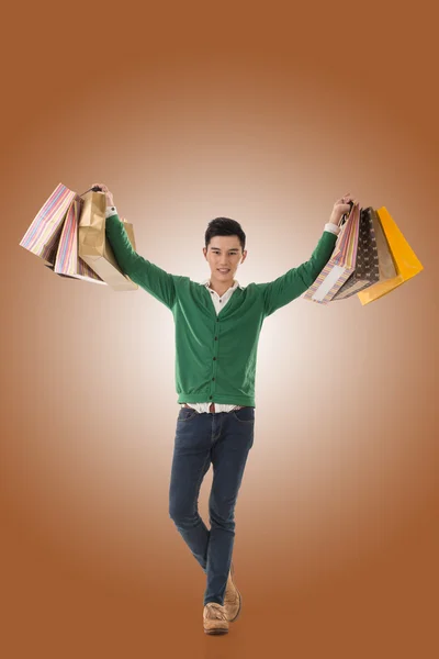 Asian young man holding shopping bags