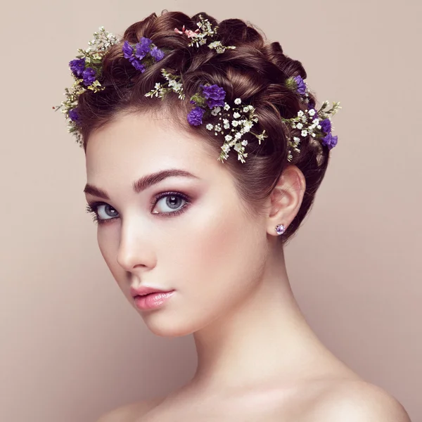 Face of beautiful woman decorated with flowers