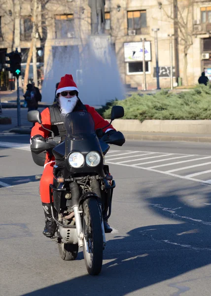 Undefined Santa delivering humanitarian aid in form of gifts to   disabled children during annual Santa Claus Motorcycle Parade on 27 December 2014 in Belgrade, Serbia