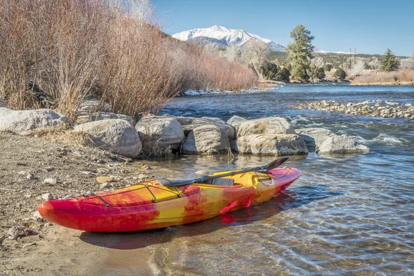 Whitewater kayak on river shore