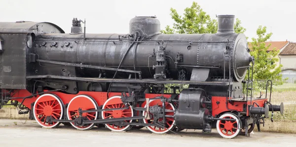 Old locomotive of a steam train, still on the asphalt, horizontal image