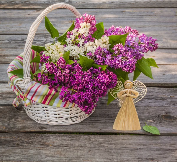 White basket with a branch of lilac