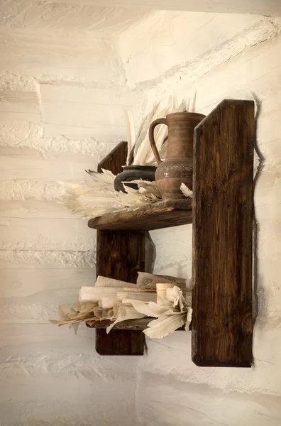 Old wooden shelf with jug, paper and pens