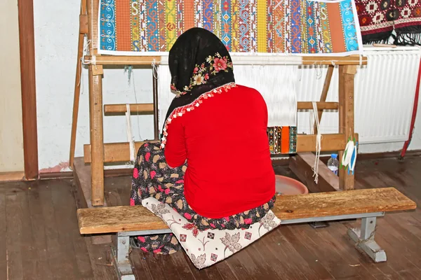 Local woman weaves a carpet by hand in Antalya, Turkey. This low-tech method has remained unchanged for centuries