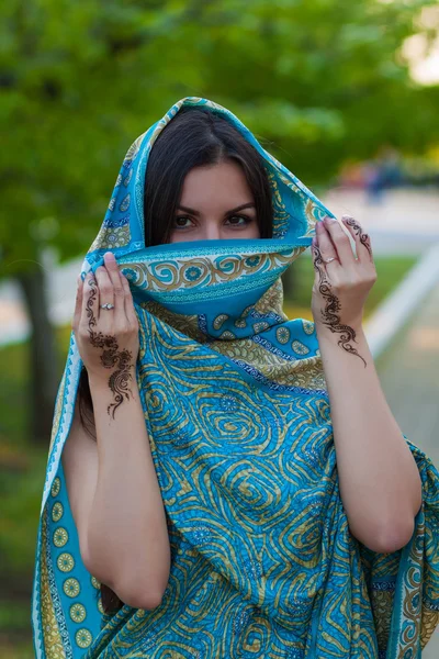 Asian woman hides her face and shows mehndi tattoo