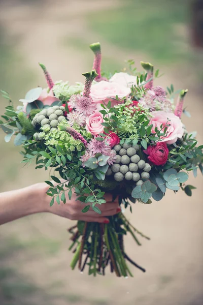 Wedding bouquet close-up, beautiful tender wedding bouquet of mixed flowers and in hands of the bride