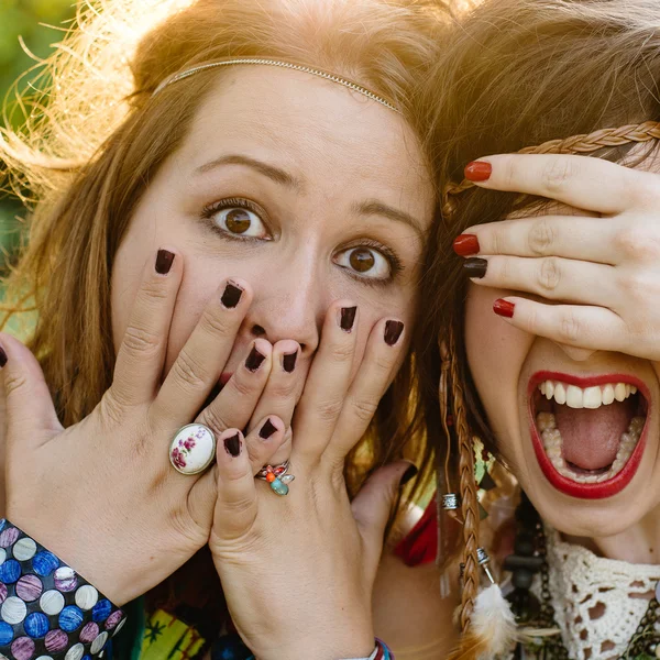 Close up fashion portrait of Two friends have fun , make grimaces ,fun emotions and shows hand signs. Pretty girls wearing summer clothes