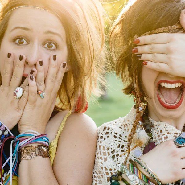 Close up fashion portrait of Two friends have fun , make grimaces ,fun emotions and shows hand signs. Pretty girls wearing summer clothes