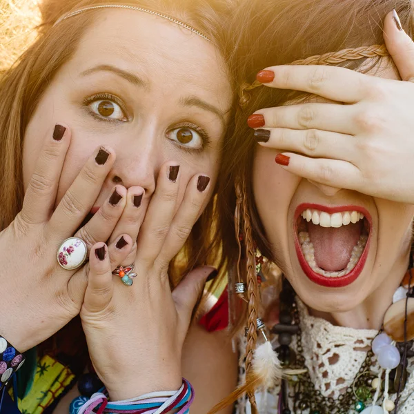 Close up fashion portrait of Two friends have fun , make grimaces ,fun emotions and shows hand signs. Pretty girls wearing summer clothes