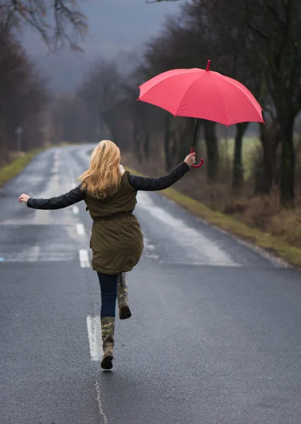 Rainy day woman holding red umbrella