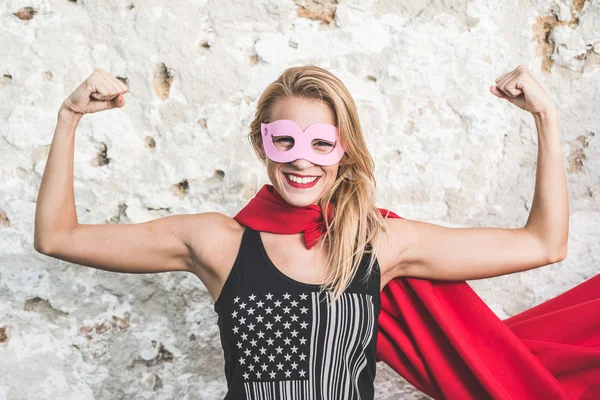 Young woman posing as superhero or superwoman