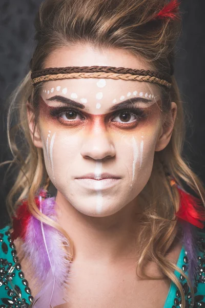 American Indian with paint face camouflage - studio photo with professional makeup