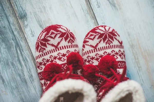 Cozy Christmas slippers on vintage wooden floor