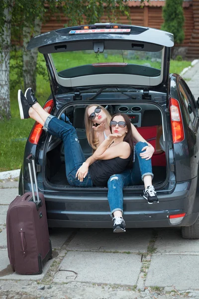 Two girls posing in car