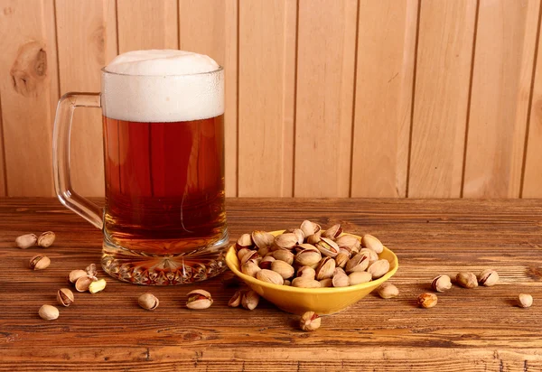 Mug with light beer and pistachios