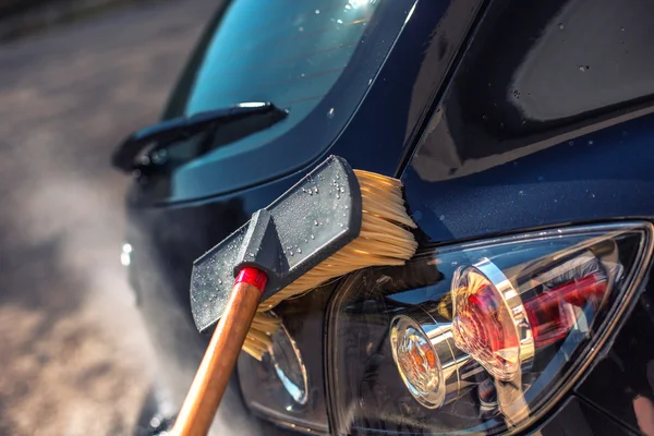 Close up of nozzle of high pressure washer used on car