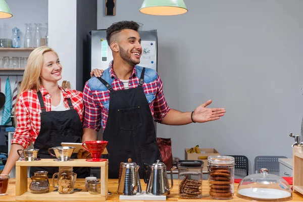 Barista coffee shop owner couple happy smile welcome at bar counter mix race man woman