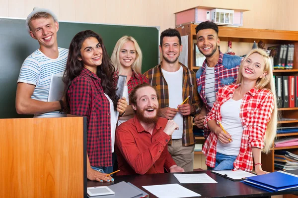 Student High School Group Laughing With Professor Sitting At Desk, Smiling Young People University Classroom