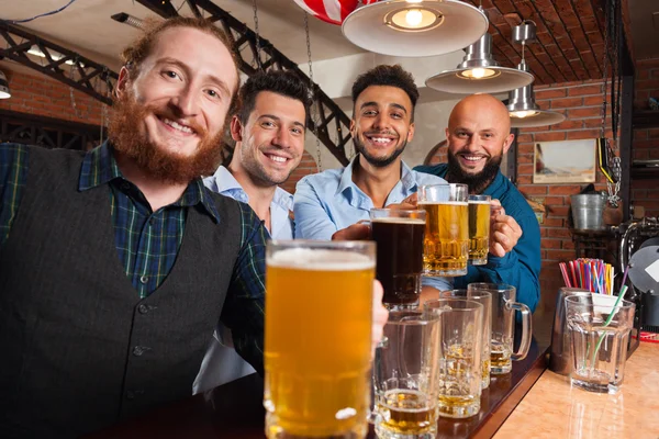 Man Group In Bar Clink Glasses Toasting, Drinking Beer Hold Mugs, Mix Race Cheerful Friends Wear Shirts