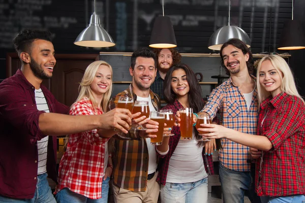 Young People Group In Bar Toasting, Hold Beer Glasses, Friends Cheers Standing At Pub,  Happy Smiling