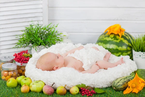 Newborn in basket with fruits and vegetables