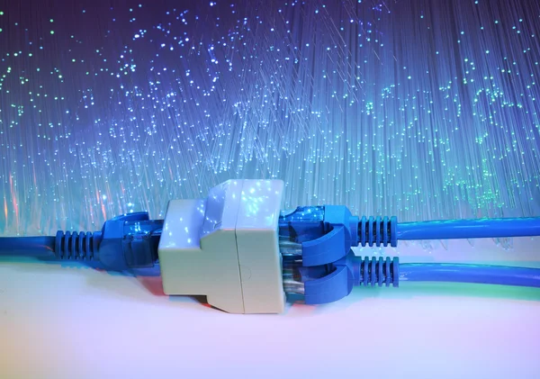 Network cables and hub closeup with fiber optical background