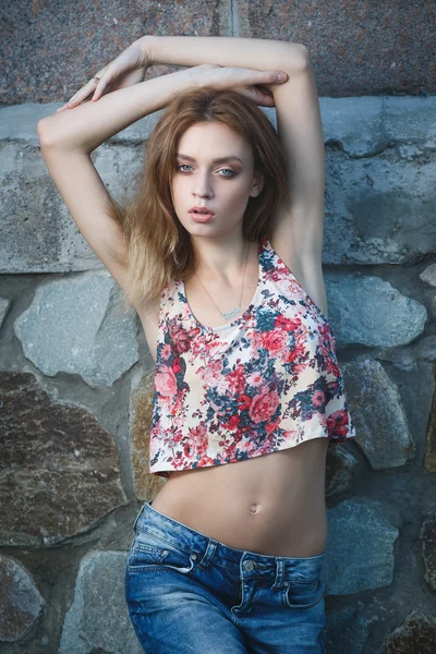 Young sexy model posing near old weathered wall