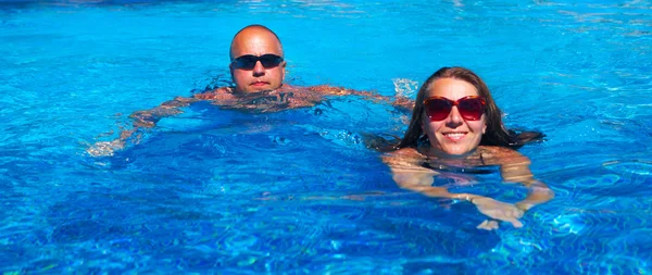 Couple swimming in pool