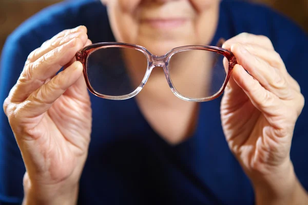 Old woman hands with eyeglasses