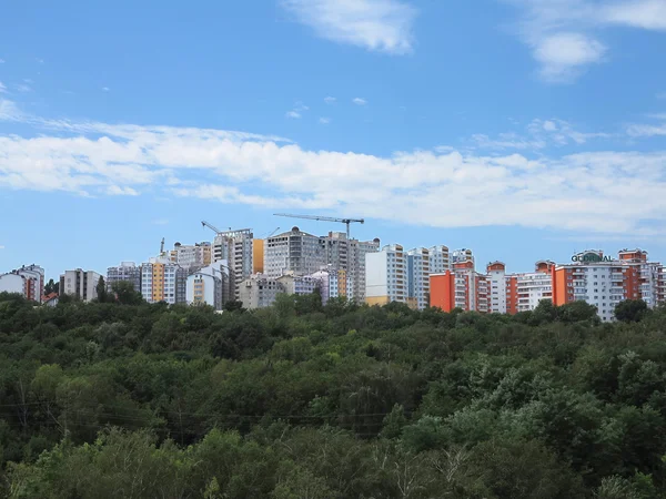 Residential modern apartment house, green forest and blue sky